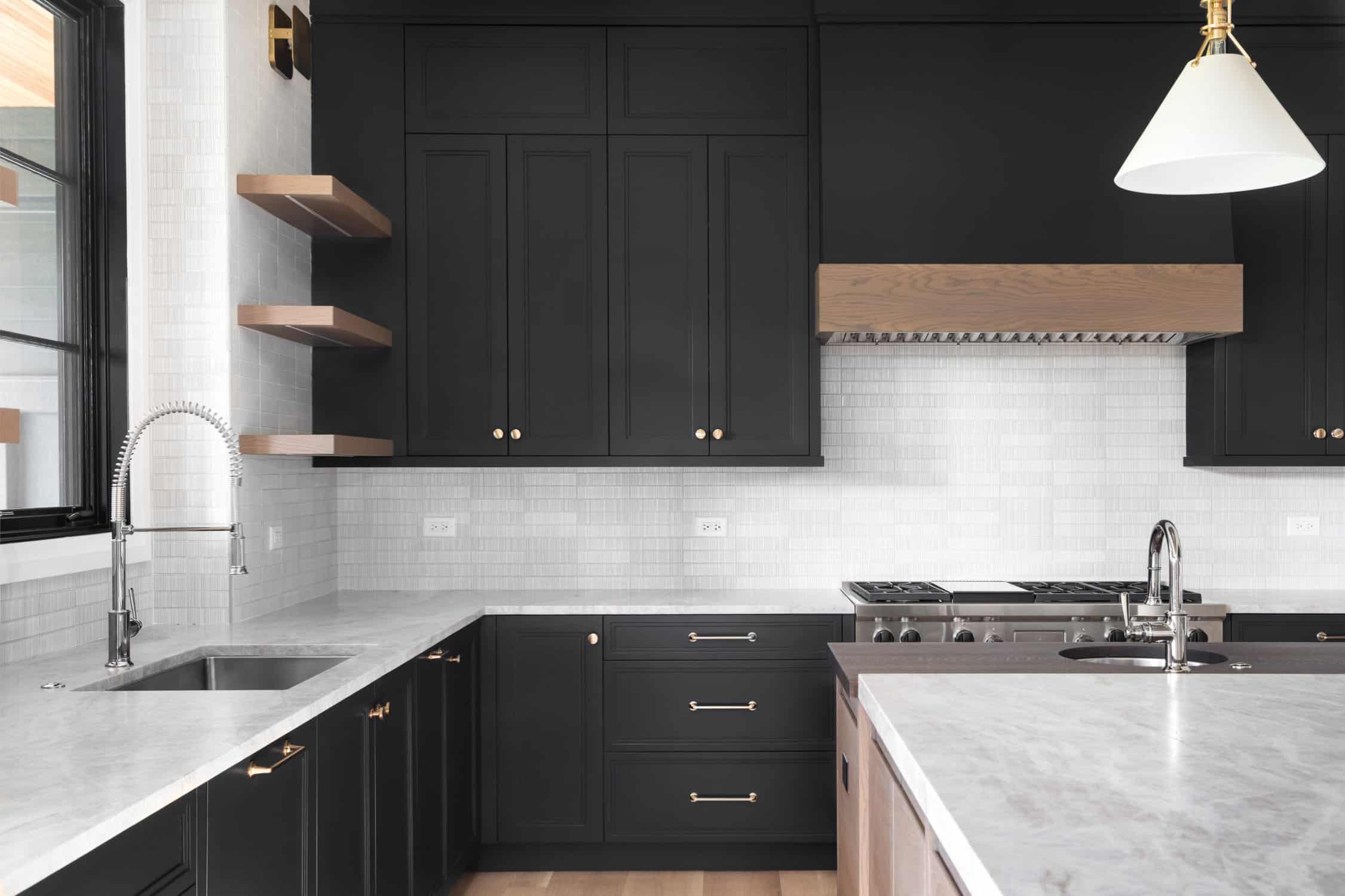 A black kitchen with stainless steel appliances- cabinet painters in Fort Collins, CO