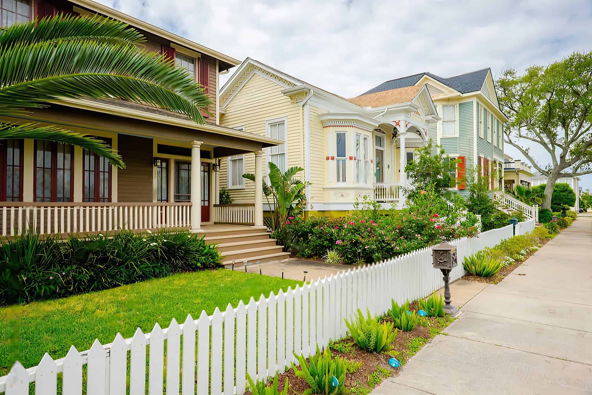 A row of houses with white painted fence