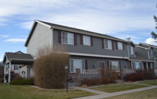 Commercial Exterior Painting for Multi Family Townhouse Complexes Freshly painted gray multi unit townhouses with maroon shutters, showcasing professional commercial exterior painting services.