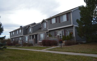 Commercial Exterior Painting for Multi Family Townhouse Complexes Freshly painted gray multi unit townhouses with maroon shutters, showcasing professional commercial exterior painting services.
