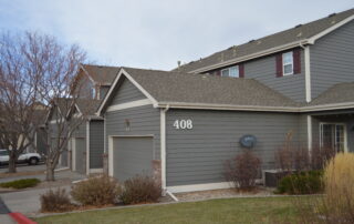 Multi Family Exterior Painting for Siding and Garage Doors Close up of a multi family townhouse unit with gray siding and a matching garage door, highlighting commercial painting.