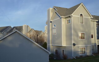 Exterior painting for multi unit residential buildings and HOA communities Modern multi unit residential buildings with light gray siding and white trim, ideal for HOA exterior painting services.