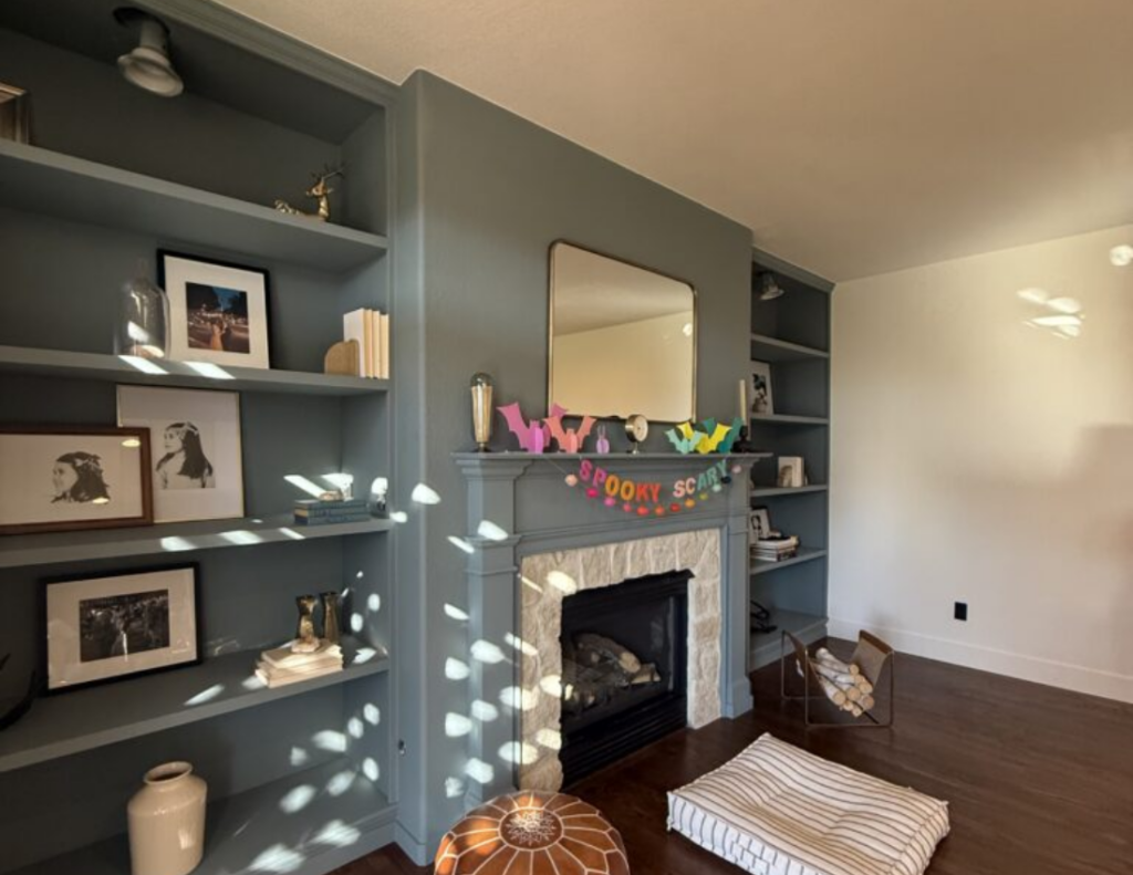 Full Interior Repaint With Color Drench Finished interior repaint with dark walls, built-in shelving, fireplace, and hardwood floor