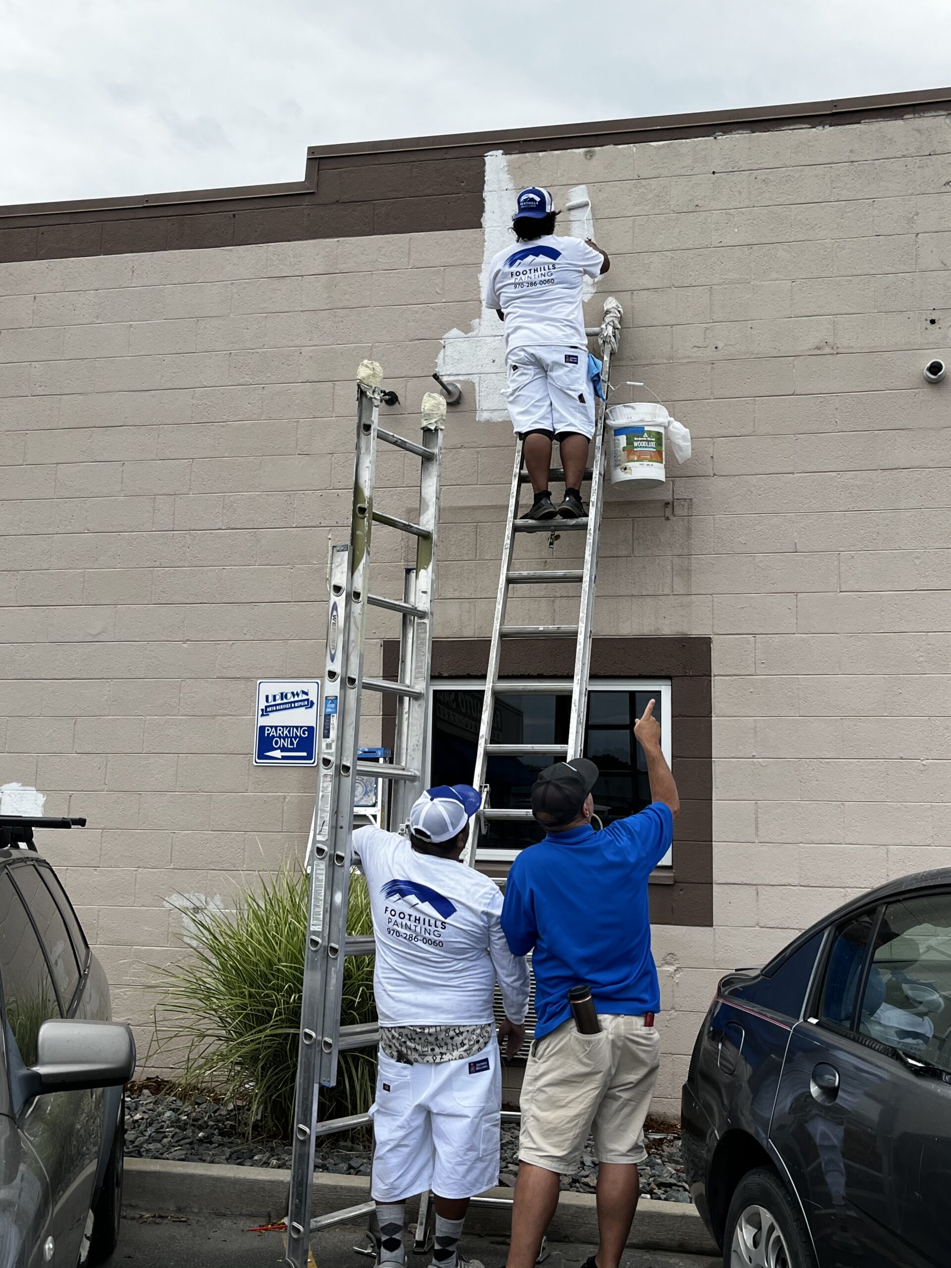 Commercial Exterior Painting Services for Businesses Professional painters applying fresh white paint to a commercial building exterior, ensuring a clean and updated finish.