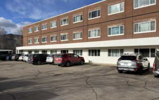 Exterior Painting for Commercial and Multi Unit Buildings Freshly painted white lower facade of a brick commercial building or apartment complex, enhancing curb appeal.