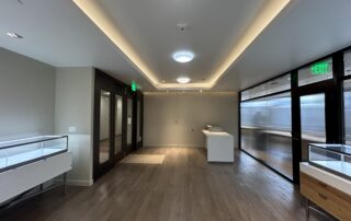 Professional Commercial Interior Painting for Modern Businesses Spacious and clean commercial interior with light walls, modern lighting, and display cases, showcasing quality painting.