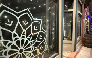 Commercial Storefront Exterior Painting Services A commercial storefront with a light painted exterior and window decal, demonstrating professional business painting.