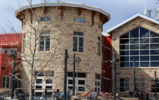 Commercial Building Exterior Painting and Renovation Exterior of a multi story commercial building with stone facade, windows, and red siding, perfect for commercial painting services.