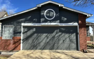 A newly painted dark gray garage door and siding with white trim enhances the home's curb appeal.