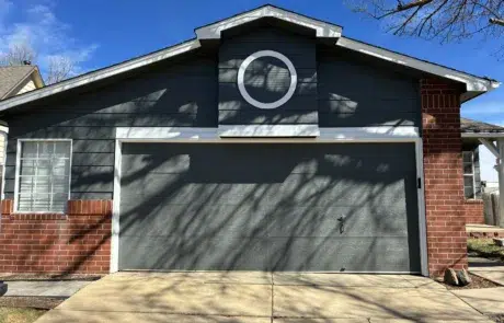 Modern Gray Garage Door and Home Exterior Painting A newly painted dark gray garage door and siding with white trim enhances the home's curb appeal.