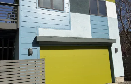 Contemporary Home Exterior Painting with Vibrant Colors and Yellow Garage Modern house with blue, white, gray, lime green panels, and a bright yellow garage door.