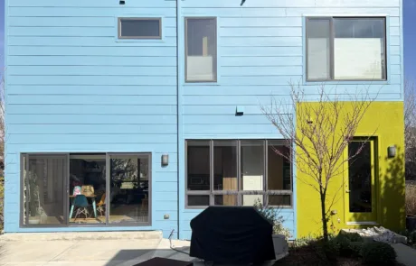 Back Exterior Painting of a Modern Home with Blue and Lime Green Accents Modern house with blue, white, gray, lime green panels, and a bright yellow garage door.