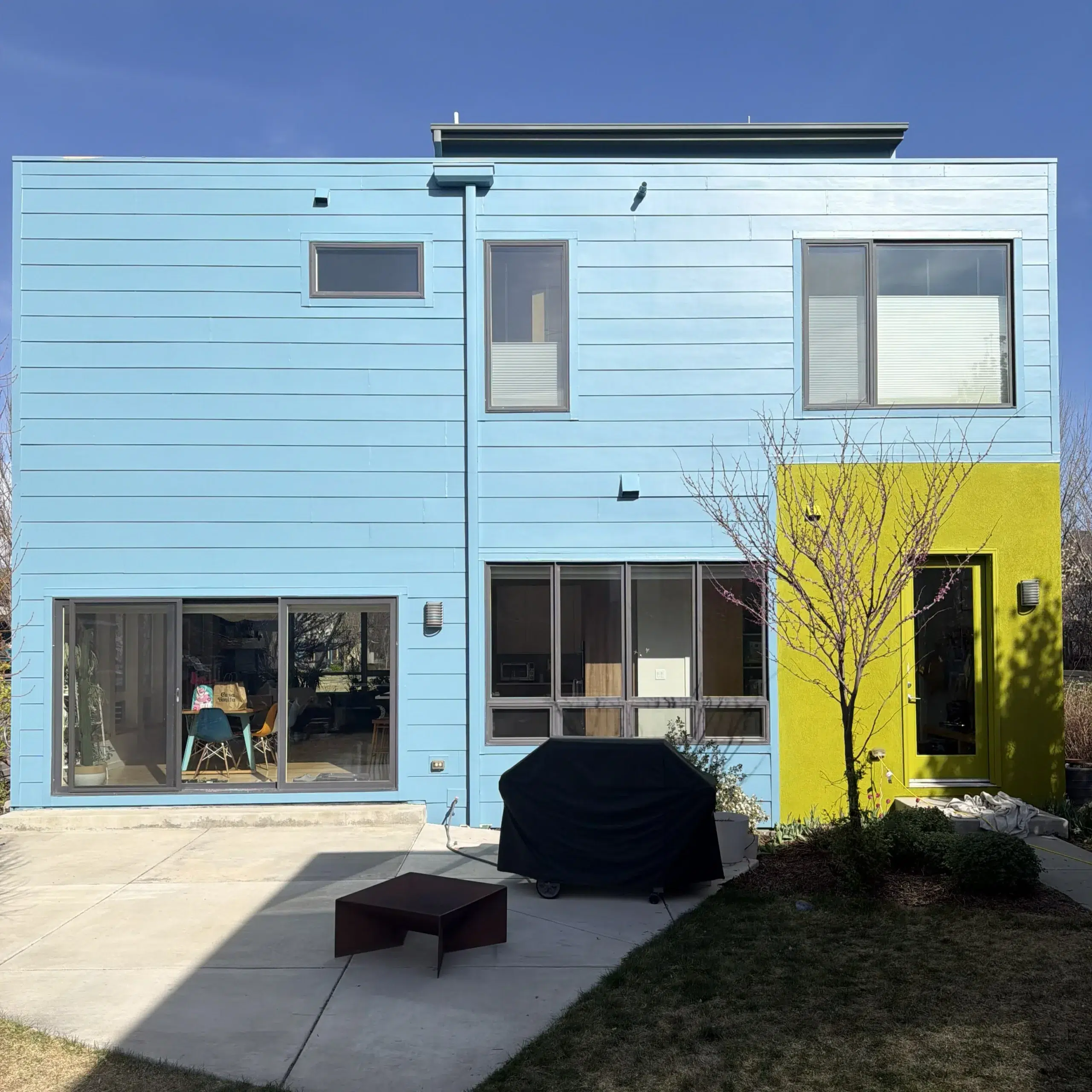 Back Exterior Painting of a Modern Home with Blue and Lime Green Accents Modern house with blue, white, gray, lime green panels, and a bright yellow garage door.