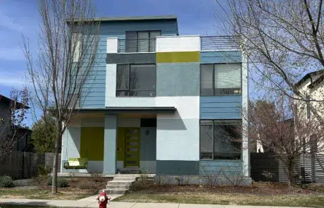 Modern Home Exterior Painting with Multi Color Design A contemporary multi story house showcasing a vibrant exterior paint job with blue, white, and lime green sections.