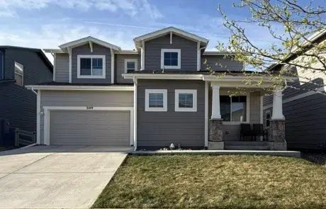 Complete Exterior House Painting Service for Enhanced Curb Appeal Front view of a beautifully painted modern house with gray siding, white trim, and a welcoming porch.
