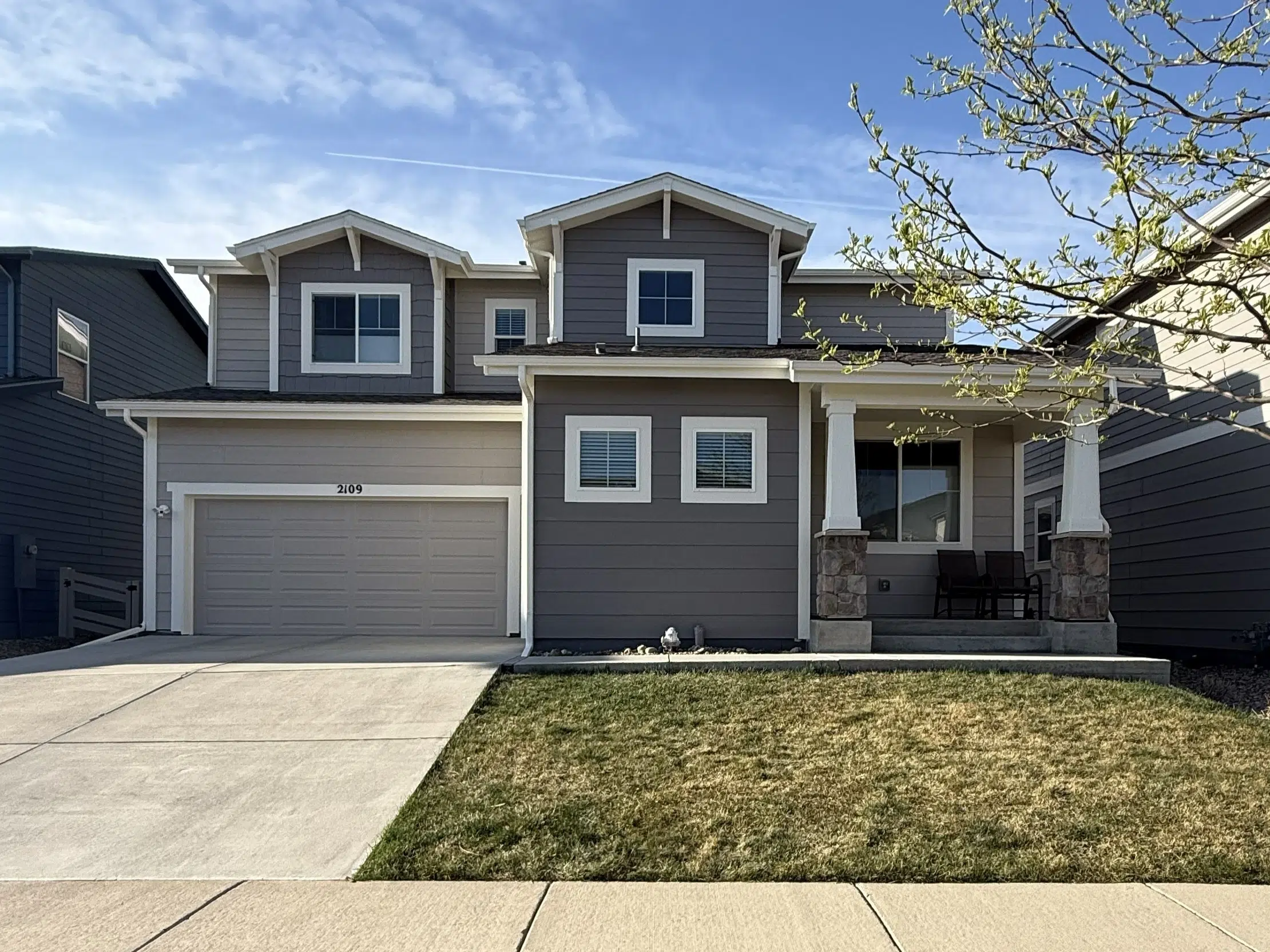Complete Exterior House Painting Service for Enhanced Curb Appeal Front view of a beautifully painted modern house with gray siding, white trim, and a welcoming porch.