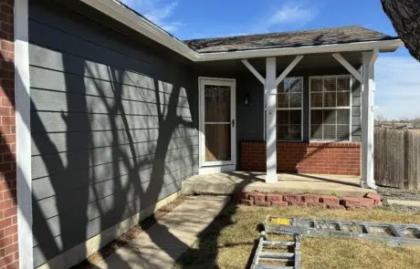 Ranch Home Exterior Painting – Charcoal Gray with White Trim Single-story ranch home with charcoal gray lap siding and crisp white trim against red brick after exterior painting