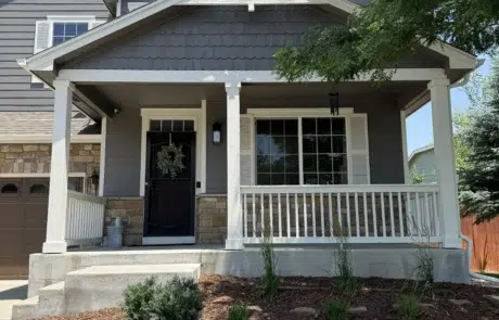 Stunning Residential Exterior Painting Enhancing Curb Appeal Full view of a charming residential house featuring gray siding, white trim, and a beautifully landscaped front yard.