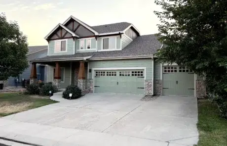Sage Green Fiber Cement Siding Home Sage green fiber cement siding two-story home with dark roof, stone veneer base, white-trimmed windows, and matching sage