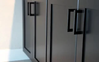 Dark Gray Painted Kitchen Cabinets Dark gray painted kitchen cabinets with black hardware and recessed panel doors in residential interior