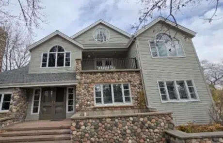Taupe Fiber Cement Siding Home Taupe fiber cement siding two-story home with white-trimmed windows, stone veneer base, and gray asphalt roof